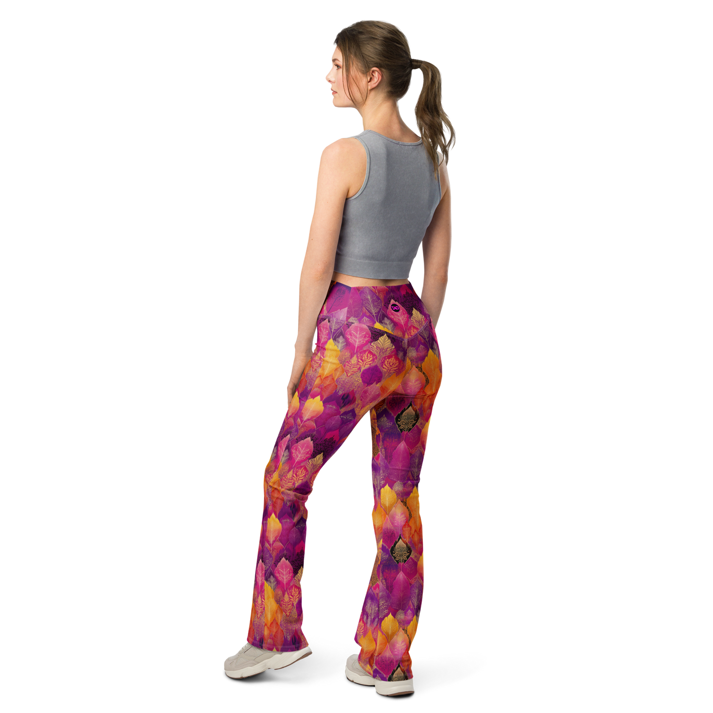 Woman wearing high-waisted flared leggings with a bold spice-toned print, featuring a supportive fit and sustainable fabric, inspired by Southeast Asian design.