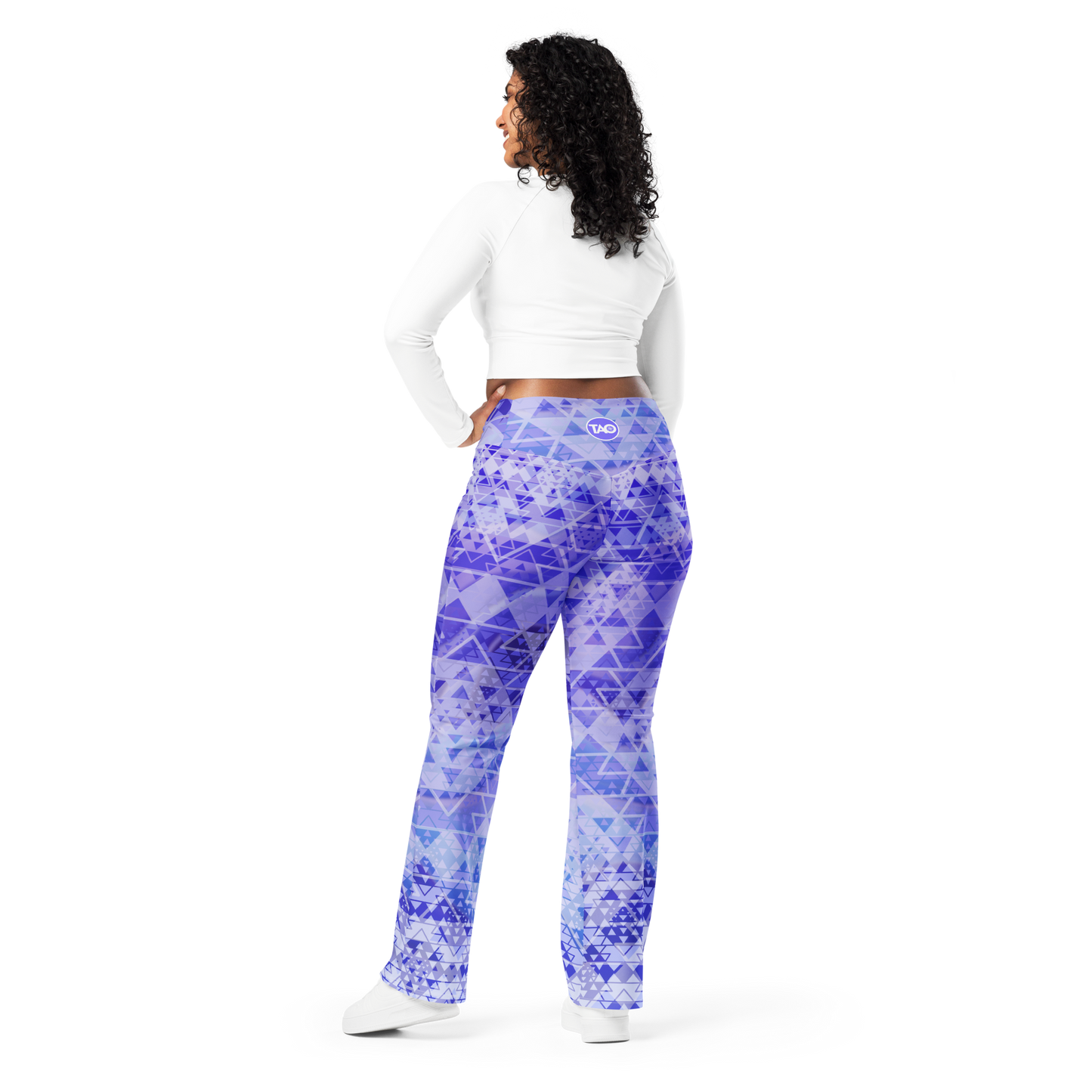 Woman wearing high-waisted flare leggings in a white, blue, and purple gradient inspired by sacred geometry, featuring a butt-lifting cut, soft compression fabric, and a double-layered waistband — designed for comfort, style, and spiritual expression.