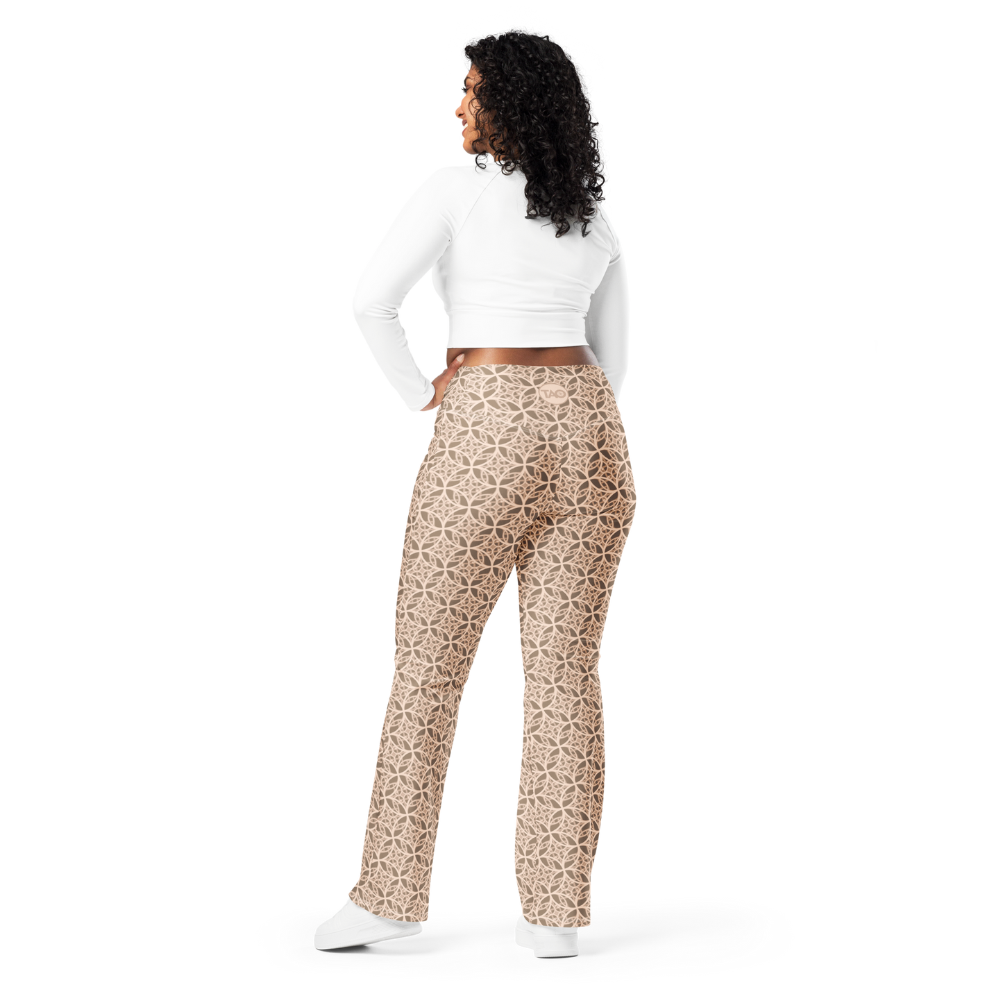 Woman wearing high-waisted beige flare leggings inspired by the Fibonacci sequence, featuring a butt-lifting cut, soft compression fabric, and a sustainable fit designed for movement, elegance, and spiritual flow.