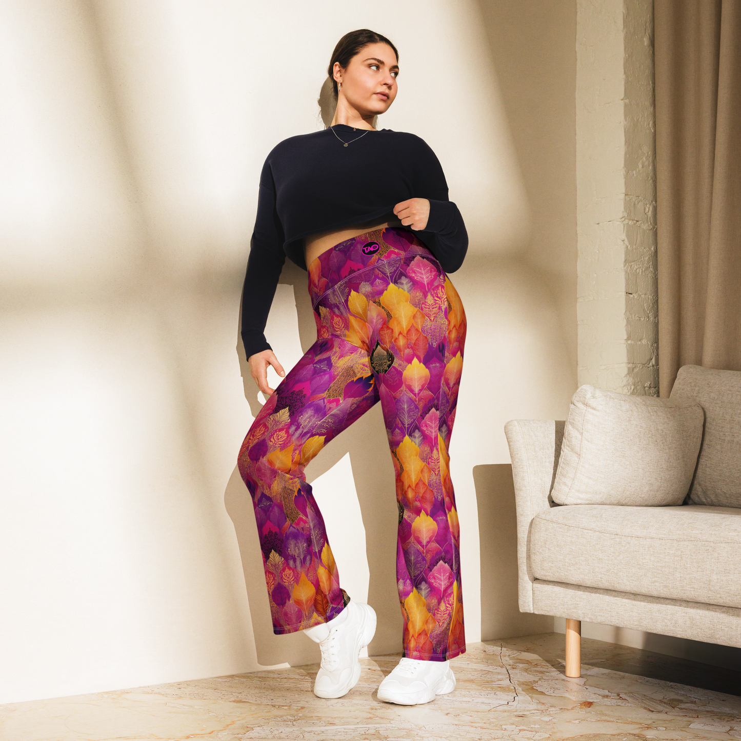 Woman wearing high-waisted flared leggings with a bold spice-toned print, featuring a supportive fit and sustainable fabric, inspired by Southeast Asian design.