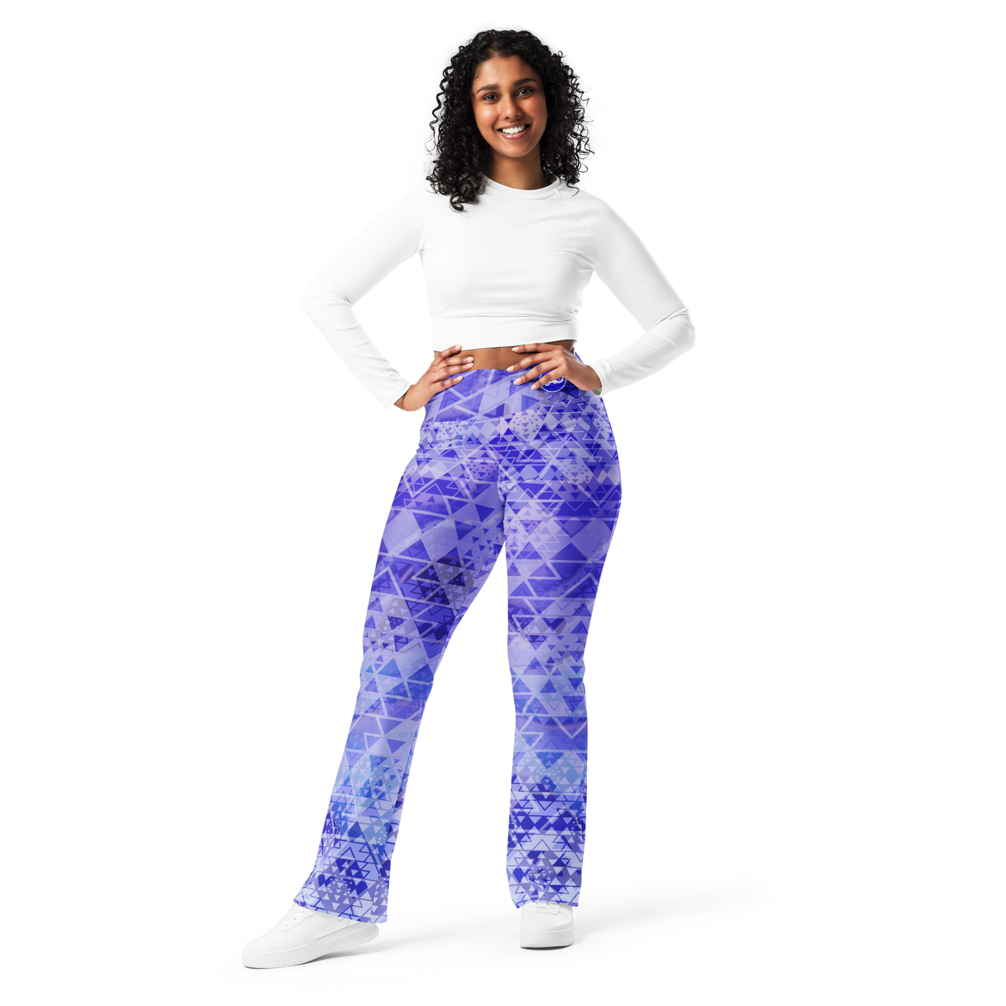Woman wearing high-waisted flare leggings in a white, blue, and purple gradient inspired by sacred geometry, featuring a butt-lifting cut, soft compression fabric, and a double-layered waistband — designed for comfort, style, and spiritual expression.