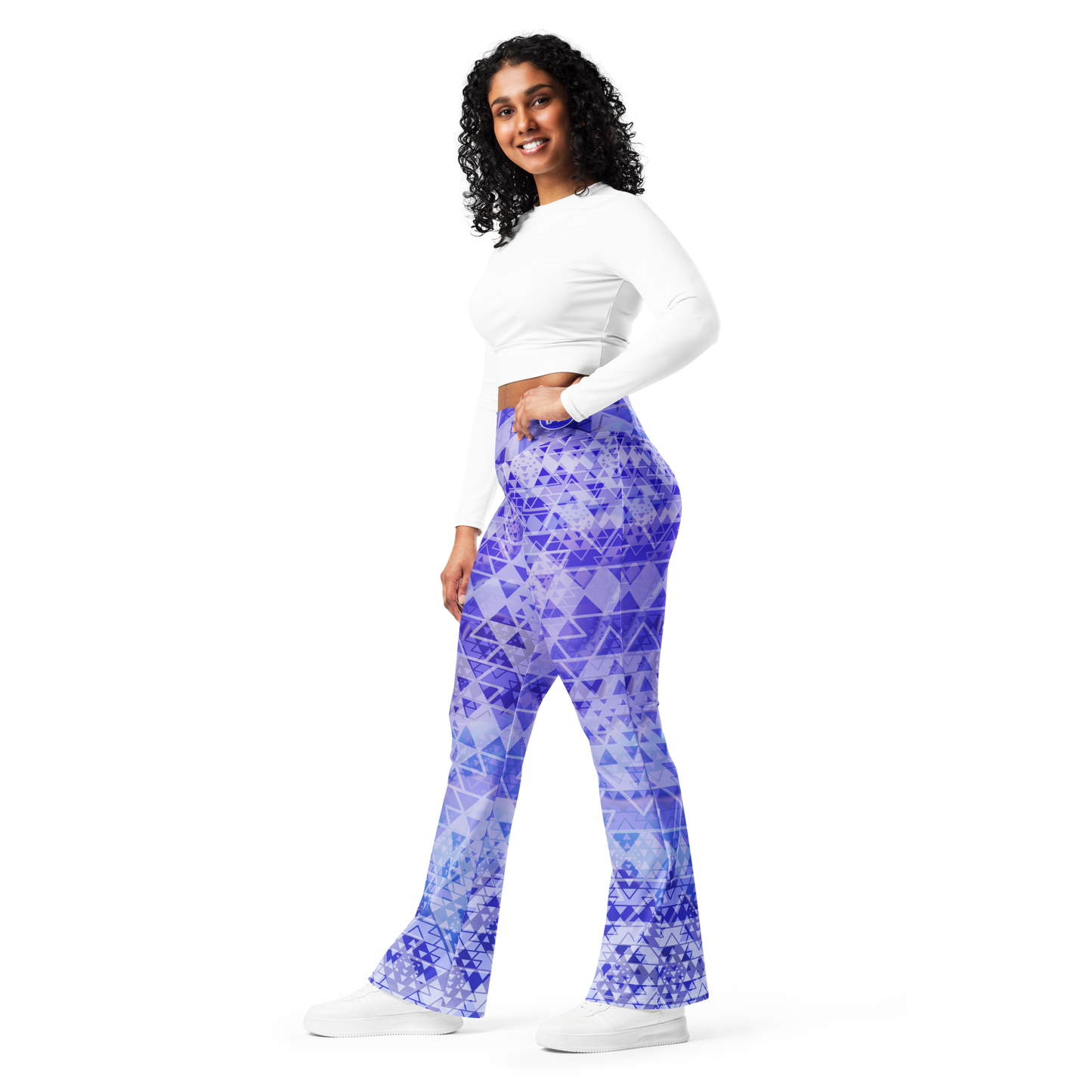 Woman wearing high-waisted flare leggings in a white, blue, and purple gradient inspired by sacred geometry, featuring a butt-lifting cut, soft compression fabric, and a double-layered waistband — designed for comfort, style, and spiritual expression.