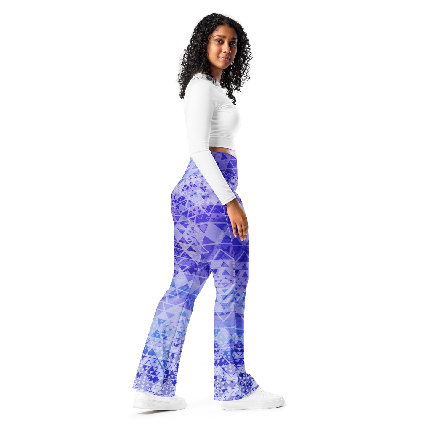 Woman wearing high-waisted flare leggings in a white, blue, and purple gradient inspired by sacred geometry, featuring a butt-lifting cut, soft compression fabric, and a double-layered waistband — designed for comfort, style, and spiritual expression.