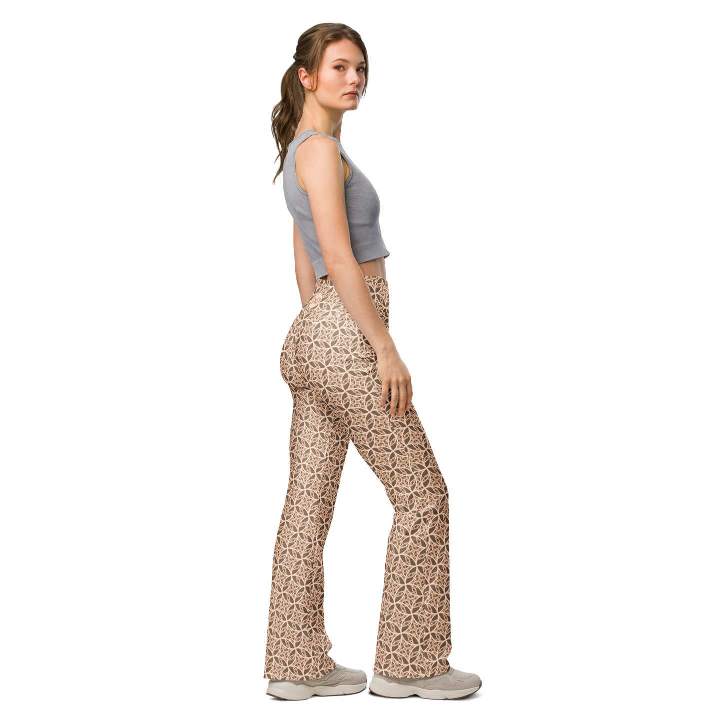 Woman wearing high-waisted beige flare leggings inspired by the Fibonacci sequence, featuring a butt-lifting cut, soft compression fabric, and a sustainable fit designed for movement, elegance, and spiritual flow.