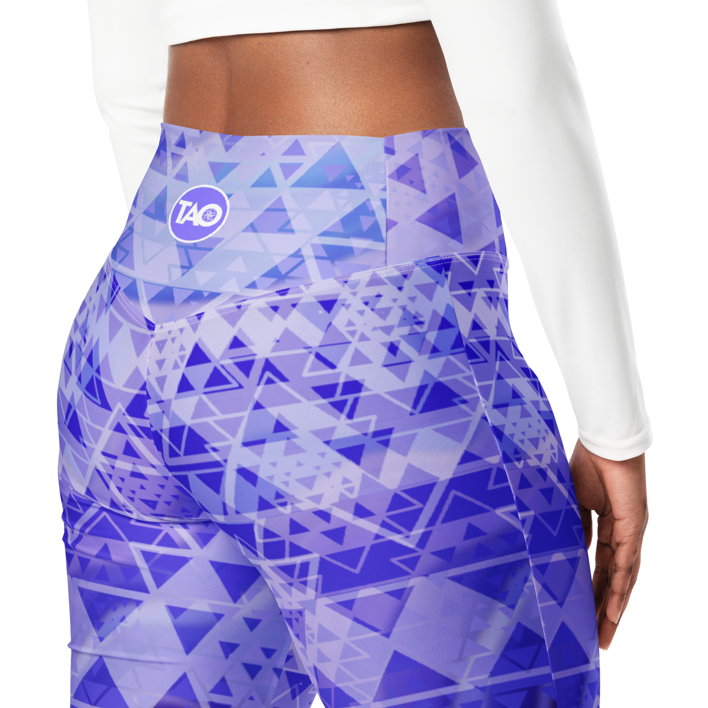 Woman wearing high-waisted flare leggings in a white, blue, and purple gradient inspired by sacred geometry, featuring a butt-lifting cut, soft compression fabric, and a double-layered waistband — designed for comfort, style, and spiritual expression.