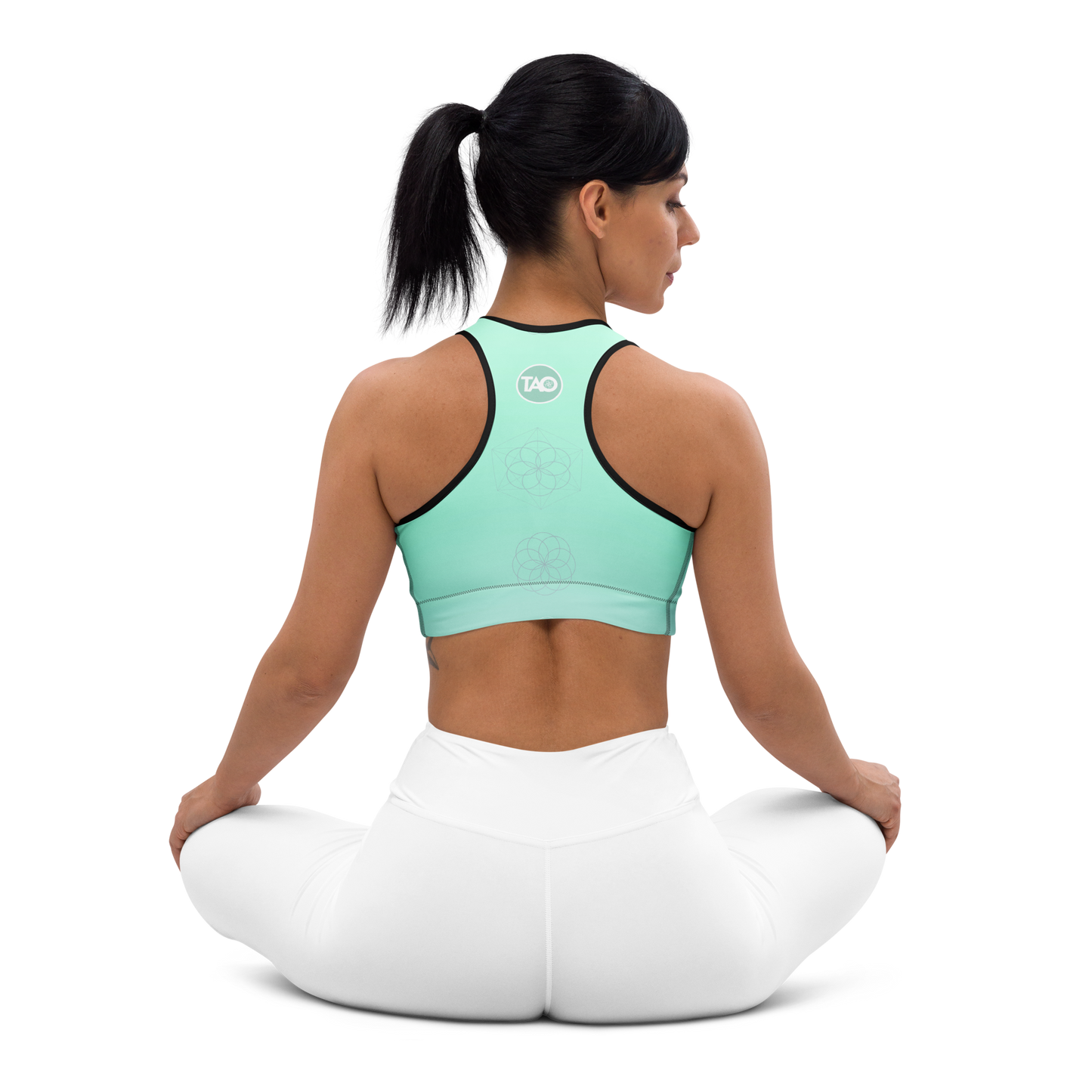 Woman wearing a mint green sports bra with sacred mandala print, scoop neckline, racerback design, and wide underband — made for flexible movement and calm, conscious strength.