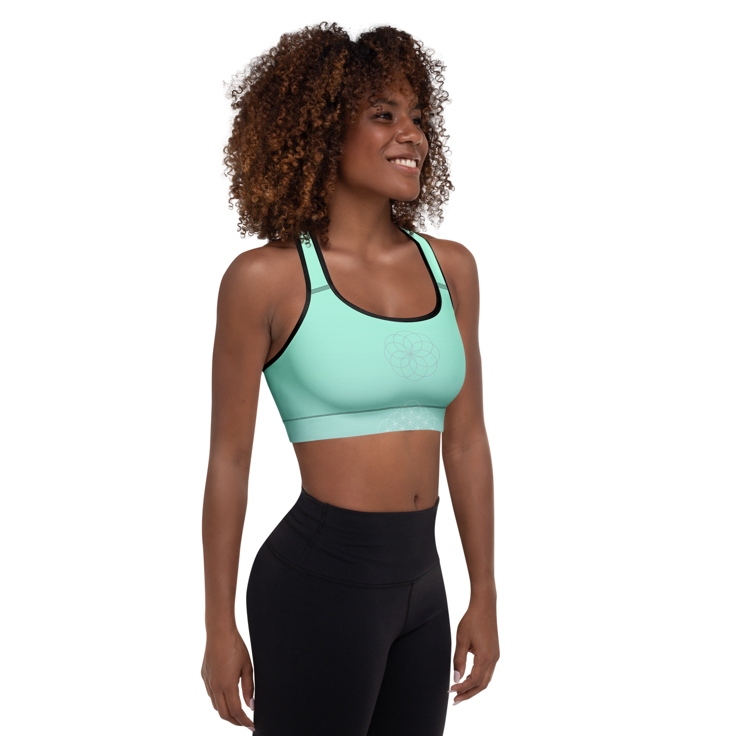 Woman wearing a mint green sports bra with sacred mandala print, scoop neckline, racerback design, and wide underband — made for flexible movement and calm, conscious strength.