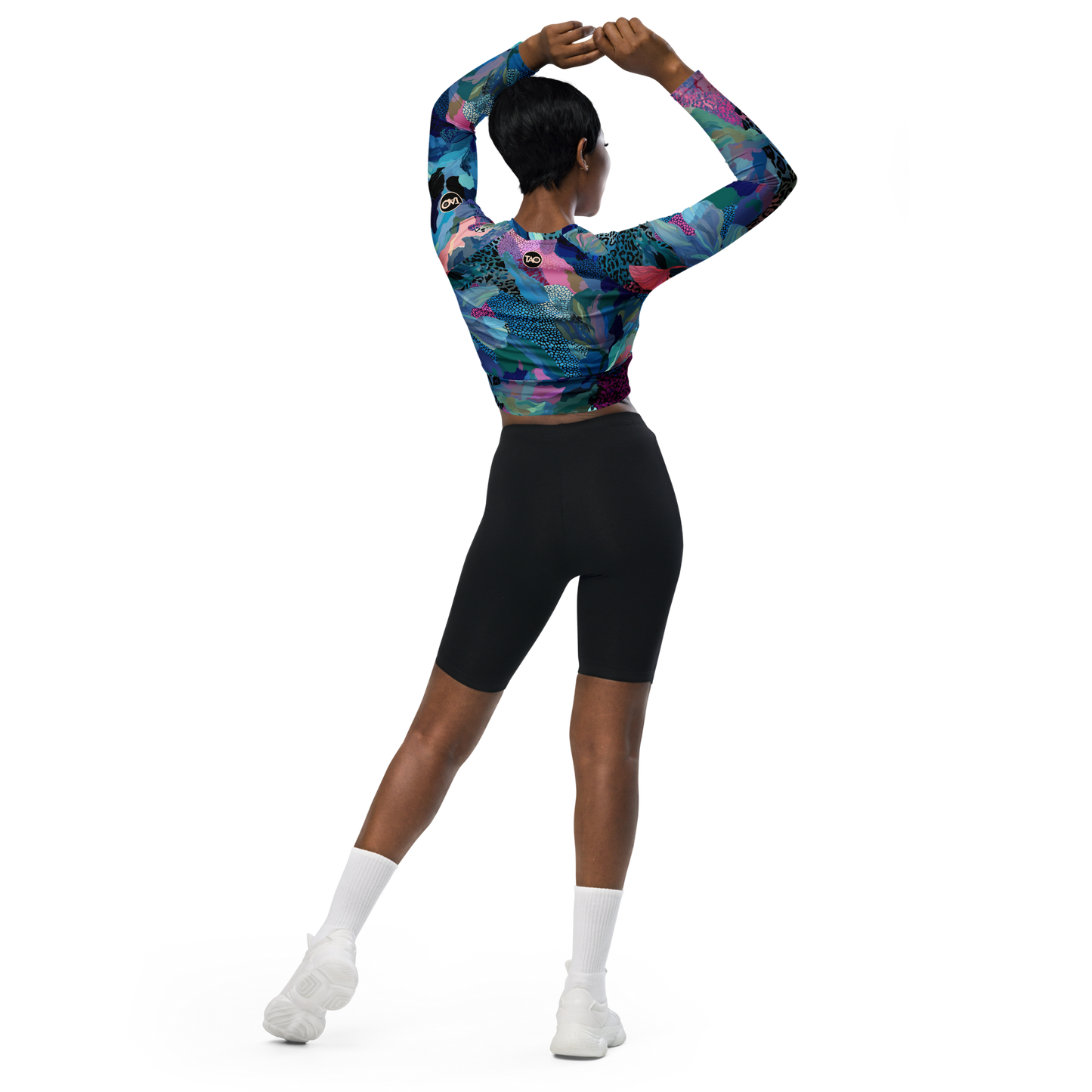 Woman wearing a blue camo-print long sleeve crop top with raglan sleeves, double-layered waistband, and UPF 50+ protection — made from recycled fabric for stylish, eco-conscious performance.