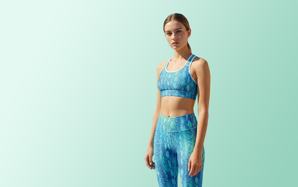 Woman wearing a blue patterned sports bra and leggings on a light green background
