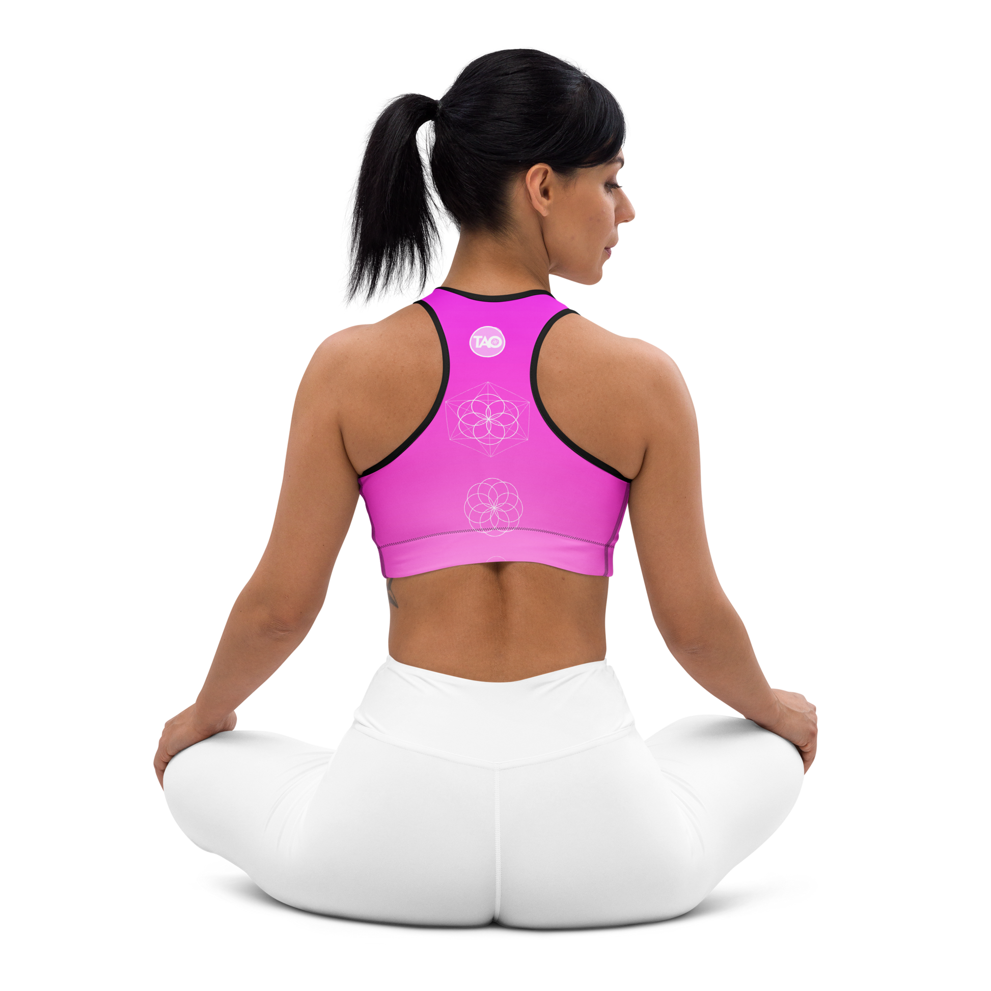 Woman wearing a soft pink sports bra with scoop neckline, racerback, wide elastic band, and removable padding — designed for flexibility, comfort, and feminine performance.
