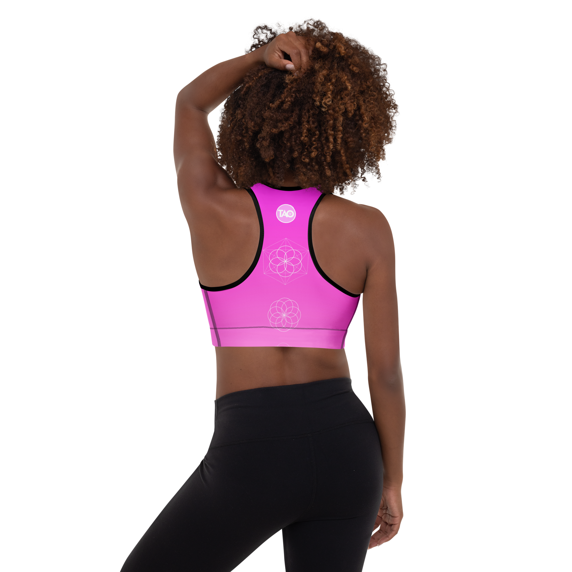 Woman wearing a soft pink sports bra with scoop neckline, racerback, wide elastic band, and removable padding — designed for flexibility, comfort, and feminine performance.
