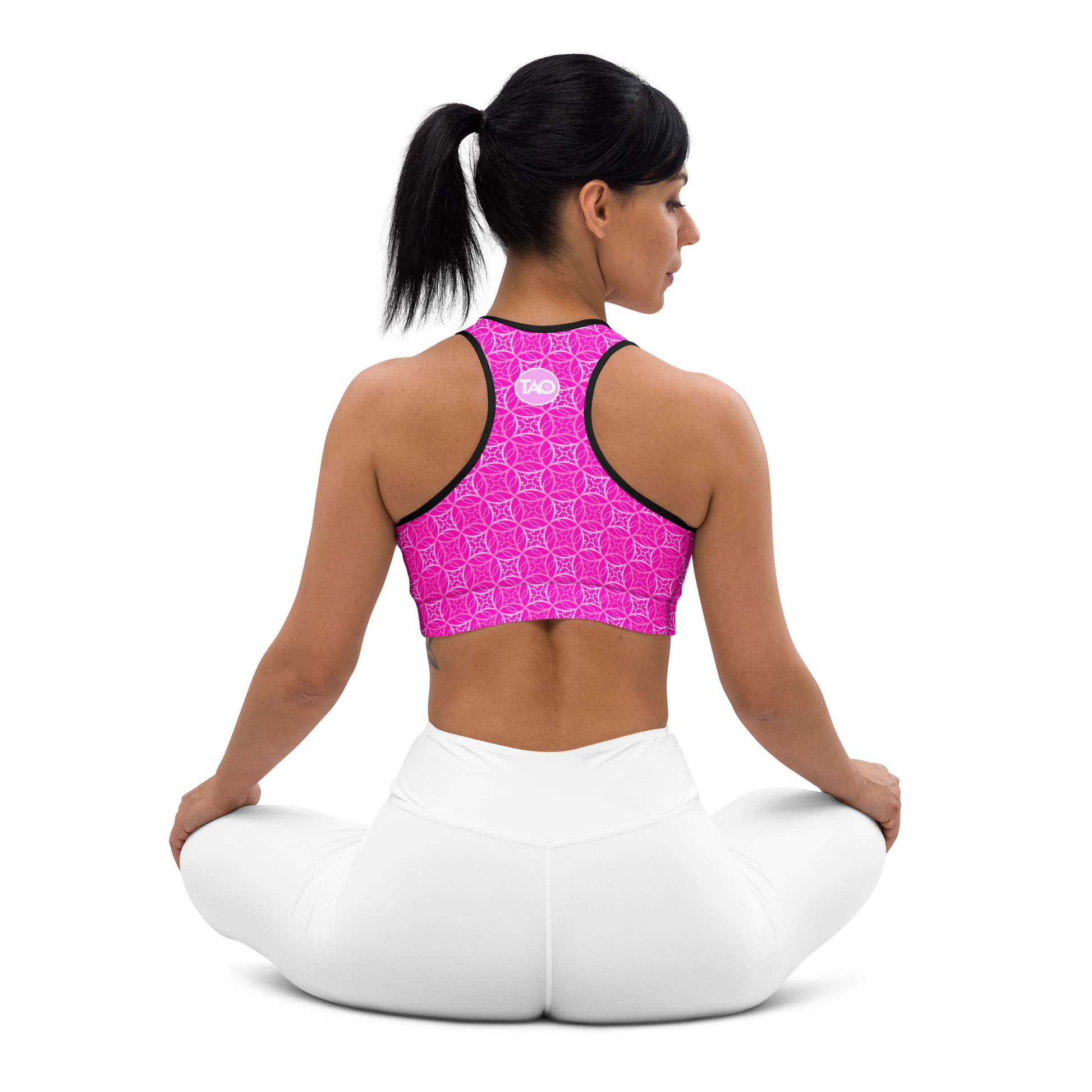 Model wearing Fibbo Pinky Sports Bra with pink sacred geometry design, featuring scoop neckline, racerback, and wide elastic band for support.