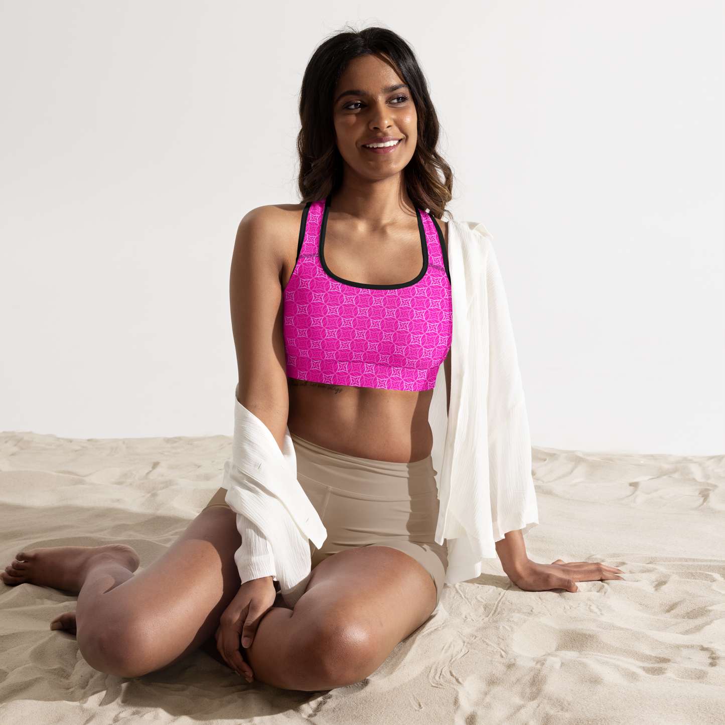 Model wearing Fibbo Pinky Sports Bra with pink sacred geometry design, featuring scoop neckline, racerback, and wide elastic band for support.