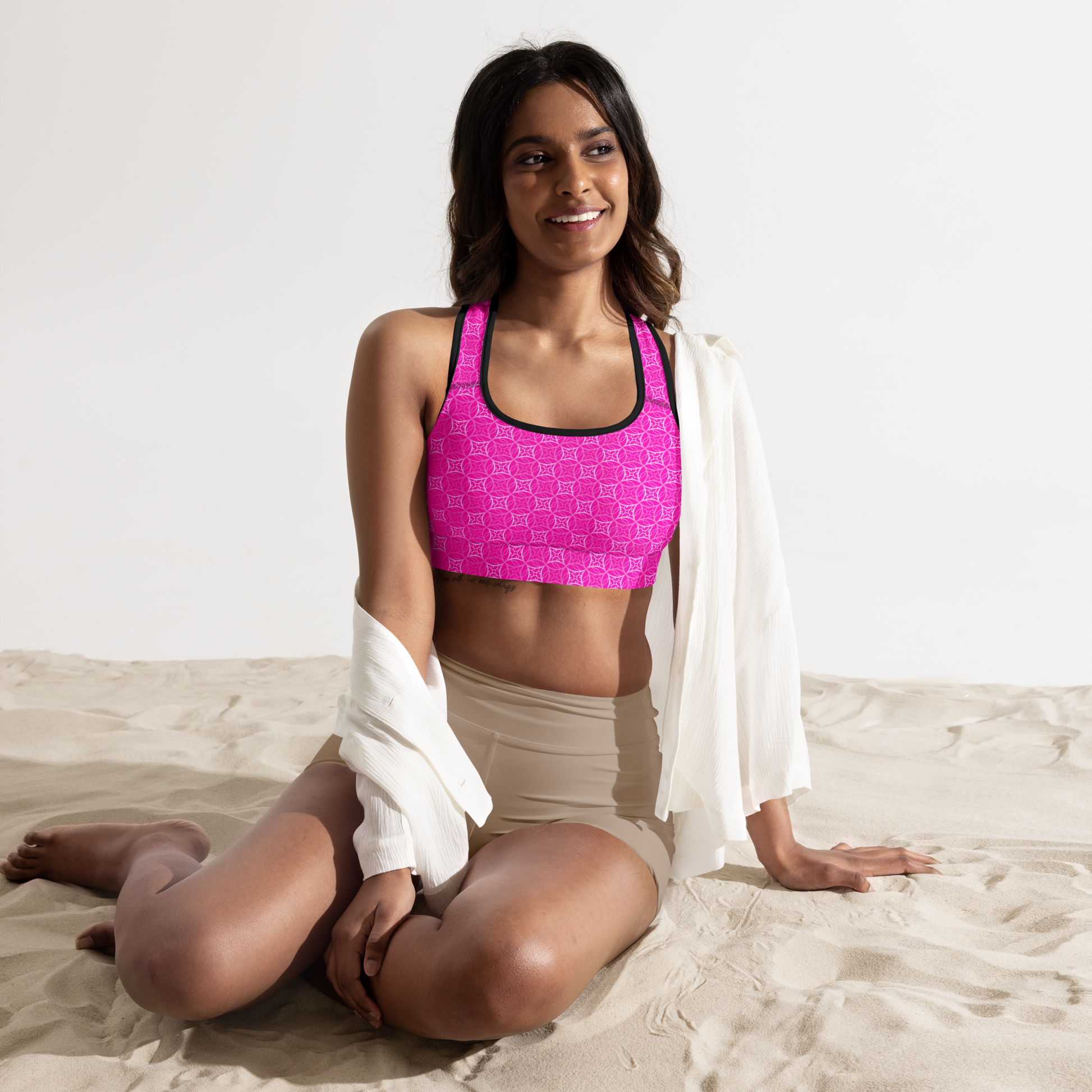 Model wearing Fibbo Pinky Sports Bra with pink sacred geometry design, featuring scoop neckline, racerback, and wide elastic band for support.