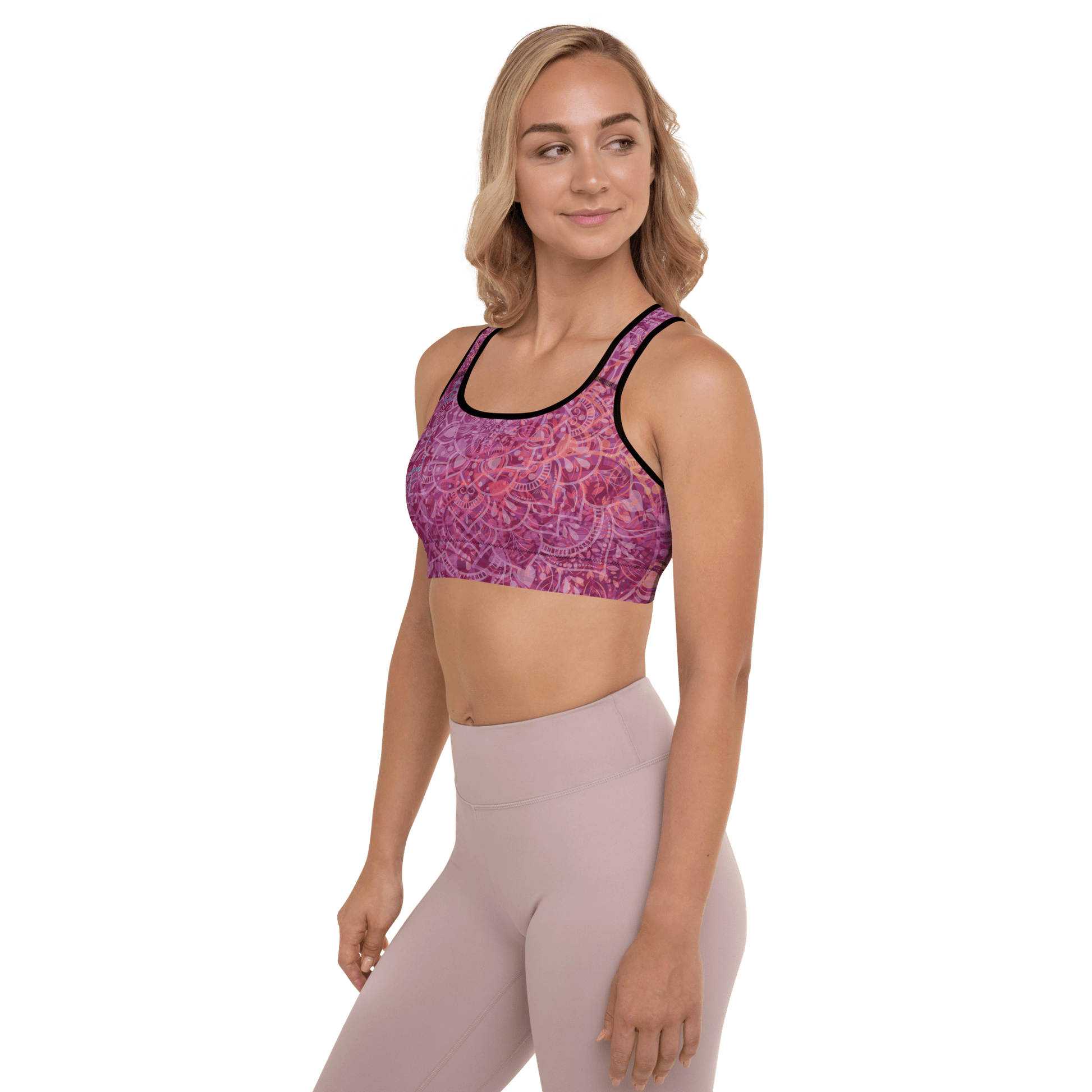 Woman in a vibrant Mandala Glow sports bra, mid-stretch in a serene outdoor yoga setting, showcasing comfort and style.