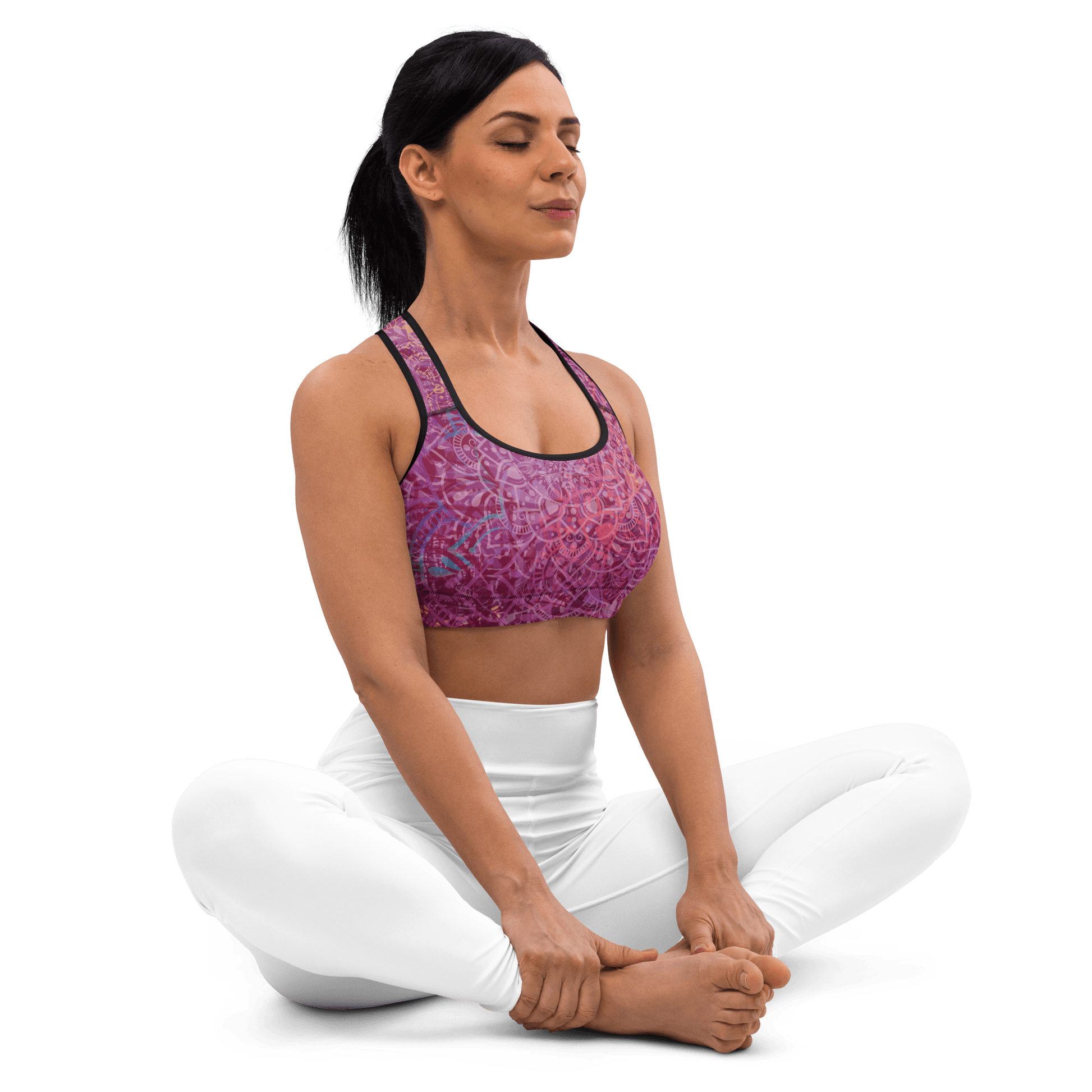 Woman in a vibrant Mandala Glow sports bra, mid-stretch in a serene outdoor yoga setting, showcasing comfort and style.