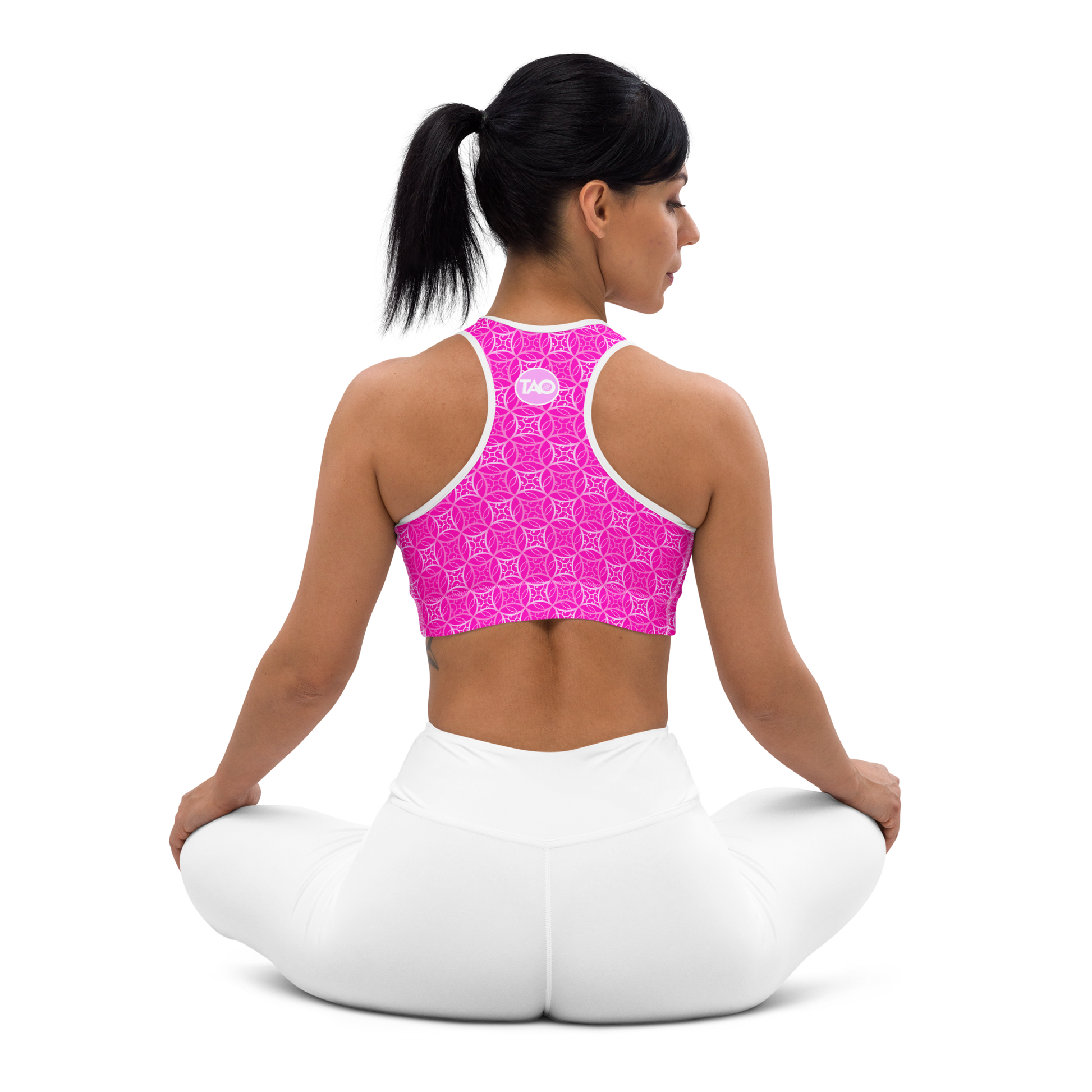 Model wearing Fibbo Pinky Sports Bra with pink sacred geometry design, featuring scoop neckline, racerback, and wide elastic band for support.