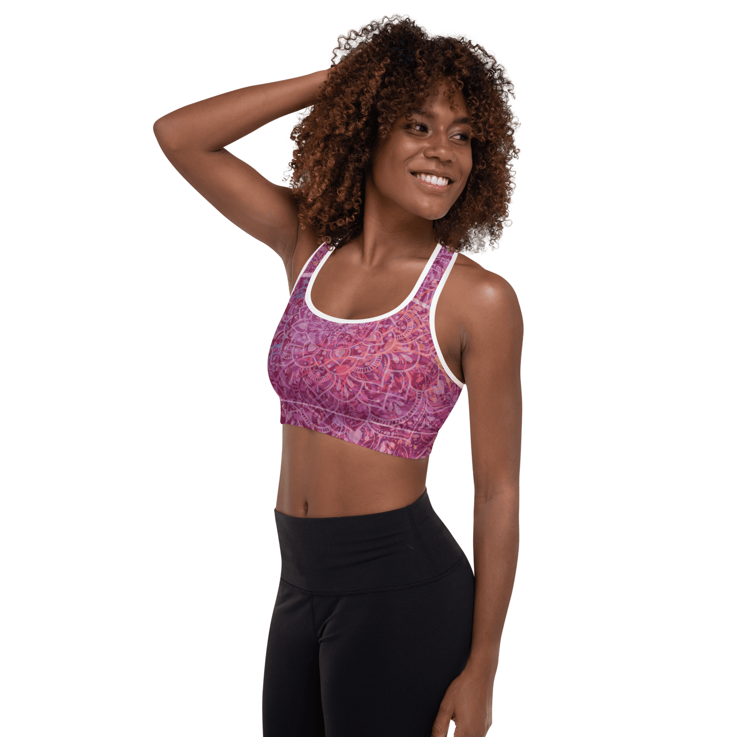 Woman in a vibrant Mandala Glow sports bra, mid-stretch in a serene outdoor yoga setting, showcasing comfort and style.