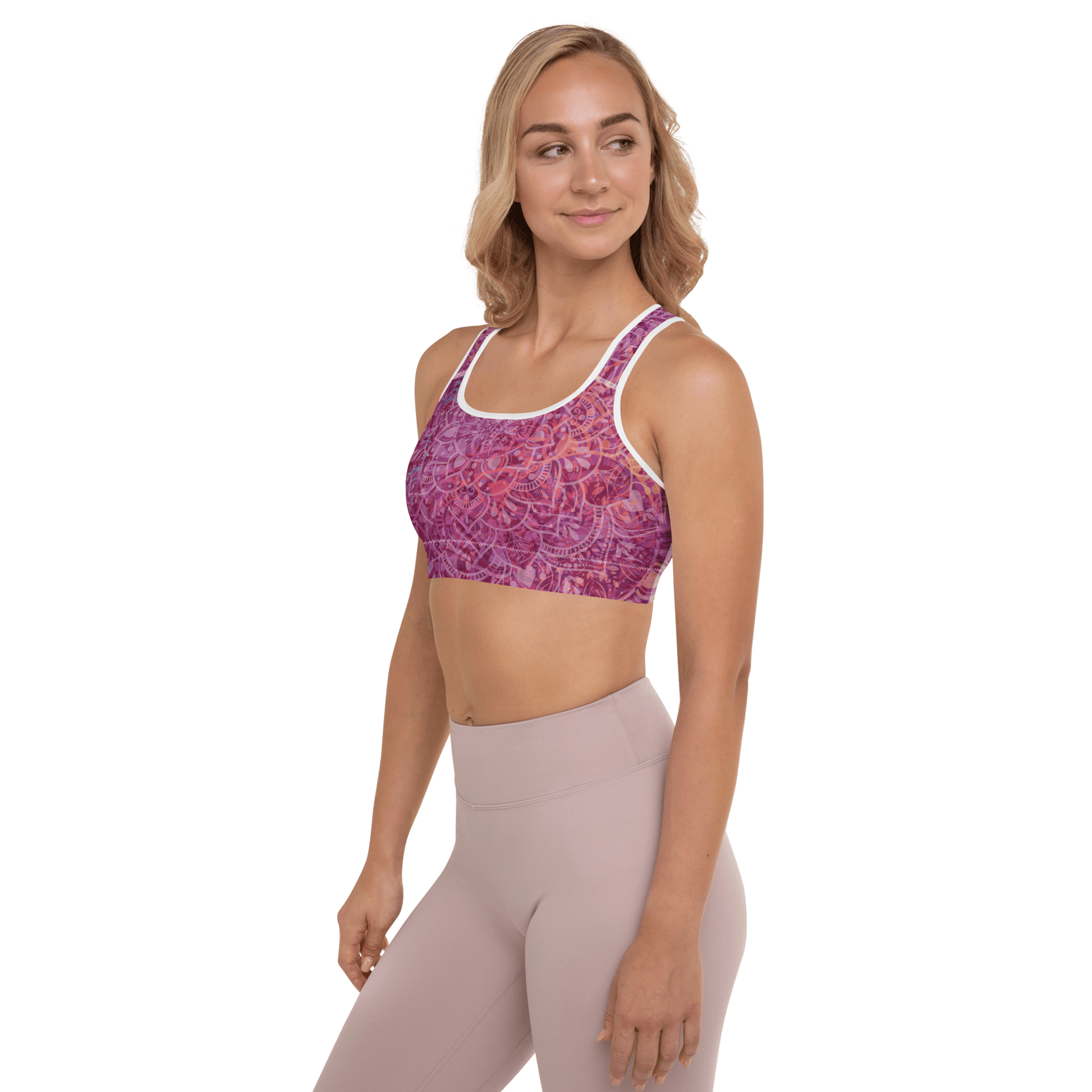 Woman in a vibrant Mandala Glow sports bra, mid-stretch in a serene outdoor yoga setting, showcasing comfort and style.