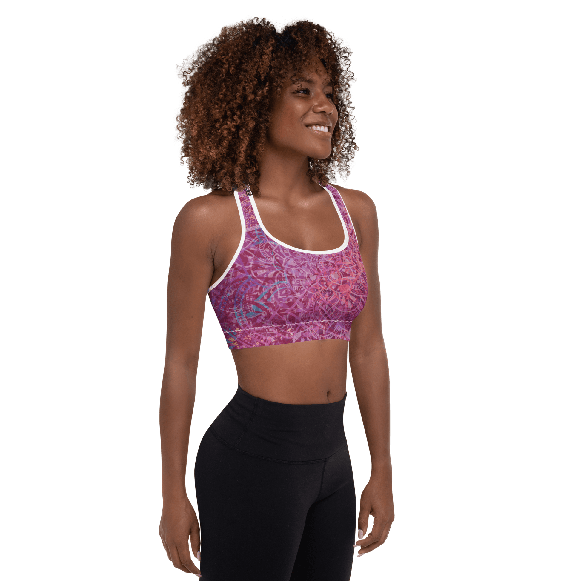 Woman in a vibrant Mandala Glow sports bra, mid-stretch in a serene outdoor yoga setting, showcasing comfort and style.