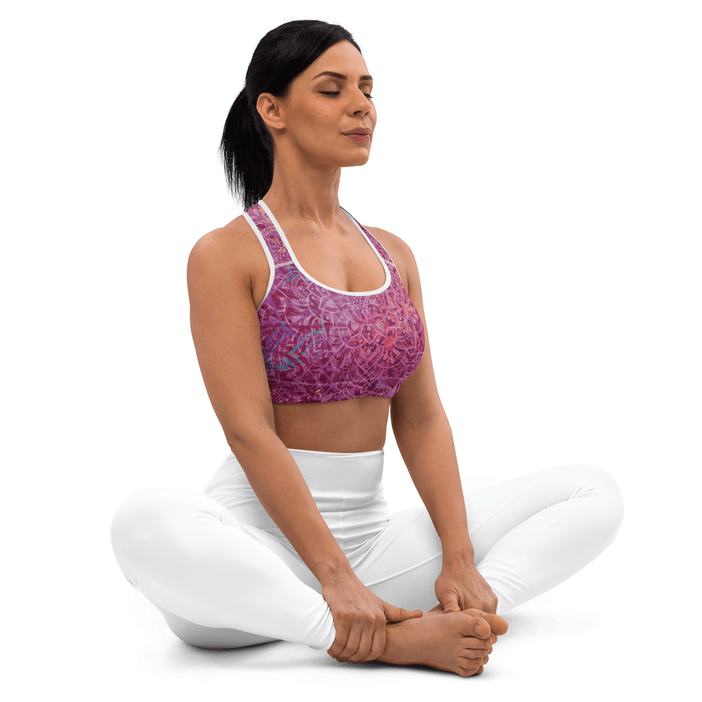 Woman in a vibrant Mandala Glow sports bra, mid-stretch in a serene outdoor yoga setting, showcasing comfort and style.