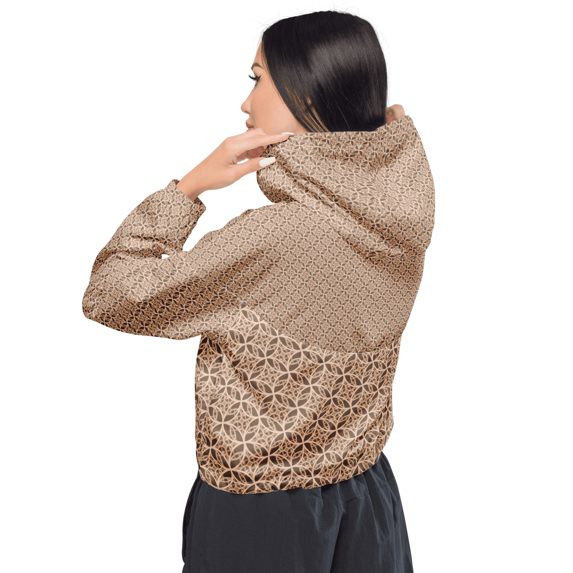 Woman wearing a lightweight beige cropped windbreaker with monogram Fibonacci pattern, featuring adjustable drawcords, side-slit pockets, and mesh lining — a waterproof, sacred-geometry inspired layer for mindful movement and conscious living.