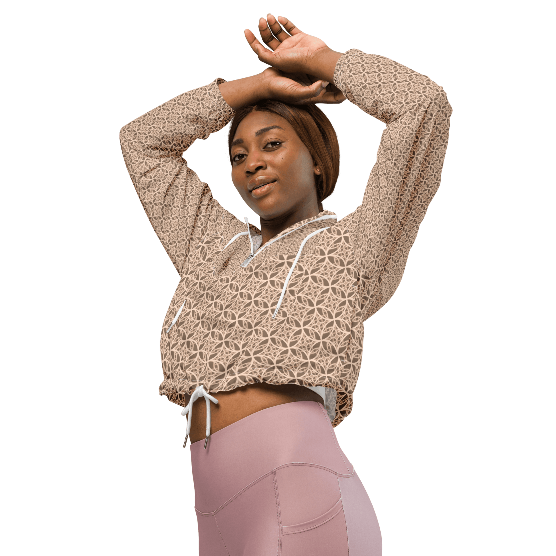 Woman wearing a lightweight beige cropped windbreaker with monogram Fibonacci pattern, featuring adjustable drawcords, side-slit pockets, and mesh lining — a waterproof, sacred-geometry inspired layer for mindful movement and conscious living.