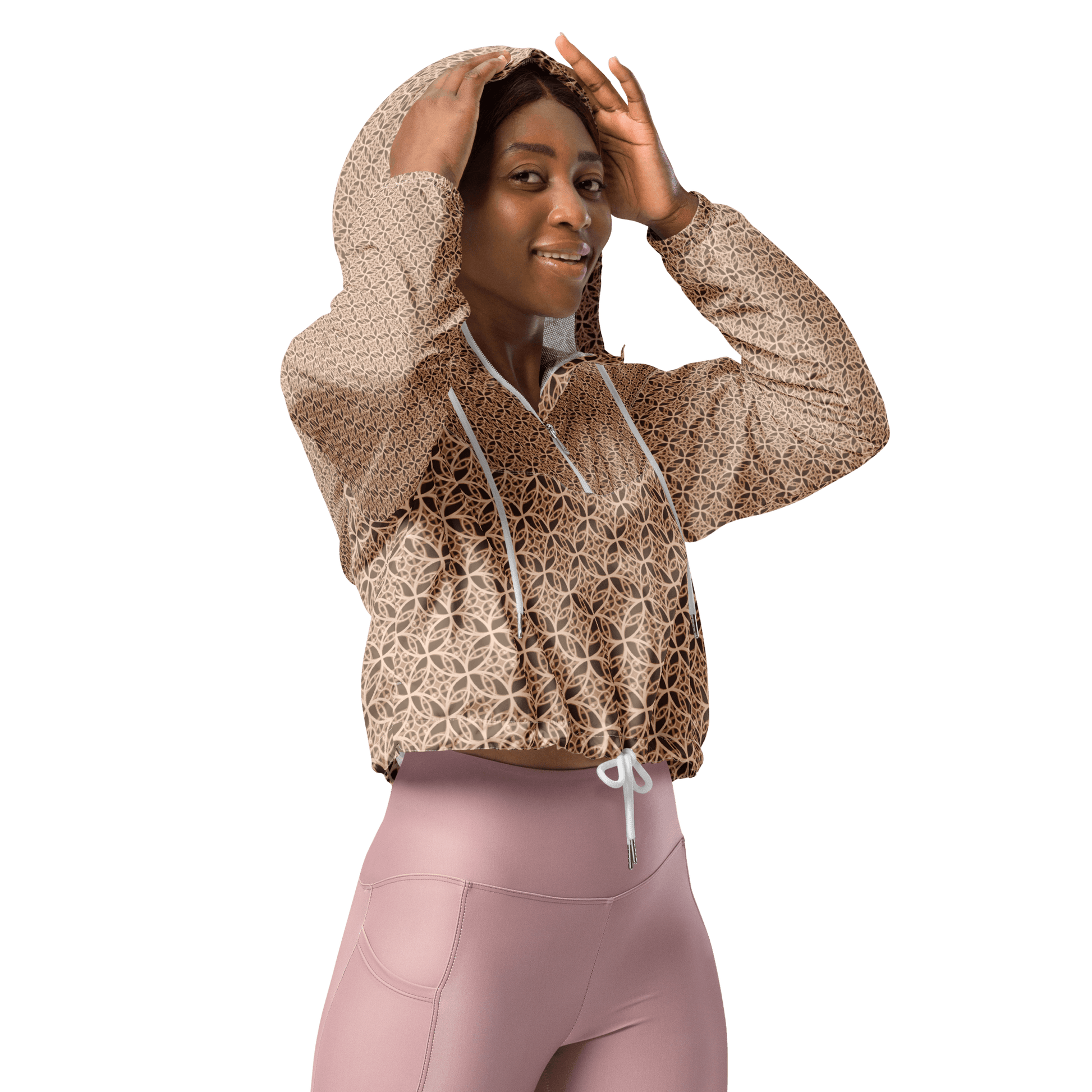 Woman wearing a lightweight beige cropped windbreaker with monogram Fibonacci pattern, featuring adjustable drawcords, side-slit pockets, and mesh lining — a waterproof, sacred-geometry inspired layer for mindful movement and conscious living.