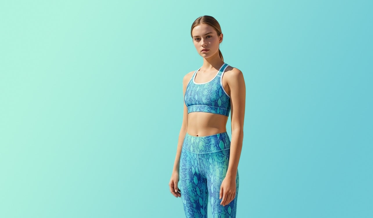 Woman wearing a blue patterned sports bra and leggings on a light blue background